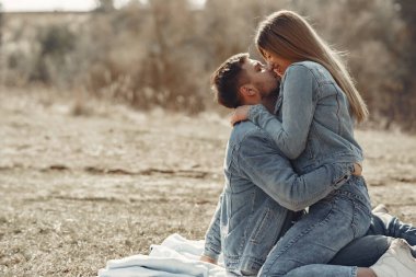 Bahar tarlasında kot pantolon giymiş sevimli bir çift.