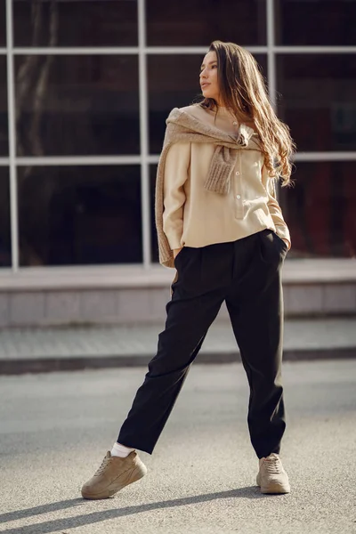 Elegante vrouw in een bruin shirt in een voorjaarsstad — Stockfoto