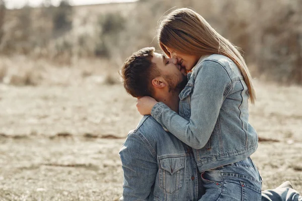 Cute couple in a jeans clothes in a spring field — Stock Photo, Image