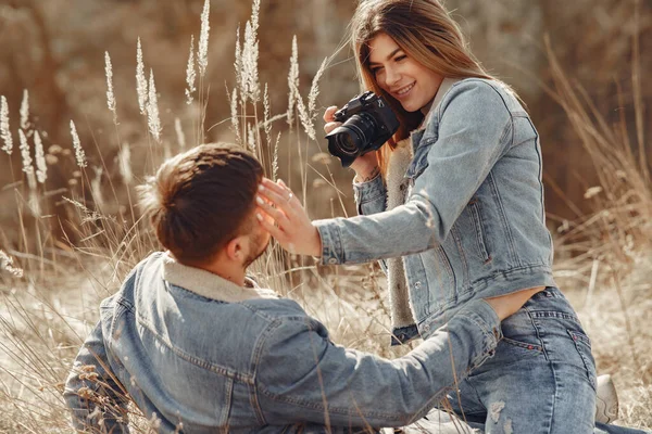 Casal bonito em uma roupa de calça em um campo de primavera — Fotografia de Stock