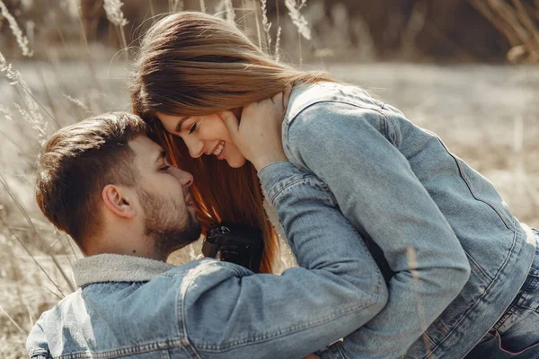 Cute couple in a jeans clothes in a spring field — Stock Photo, Image