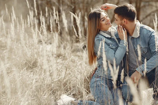 Coppia carina in vestiti di jeans in un campo di primavera — Foto Stock