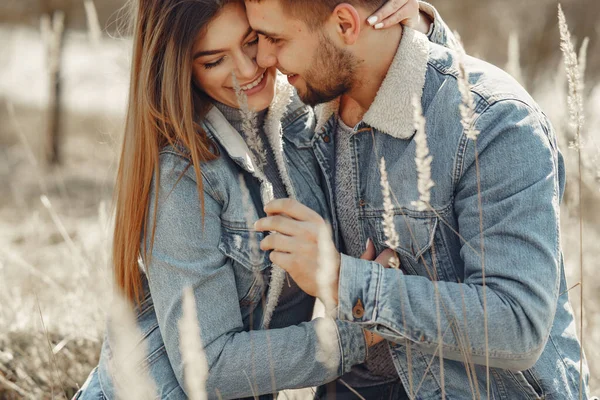 Casal bonito em uma roupa de calça em um campo de primavera — Fotografia de Stock