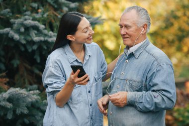 Kız, dedesine telefon kullanmayı öğretiyor.