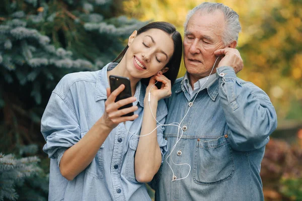 Kız, dedesine telefon kullanmayı öğretiyor.