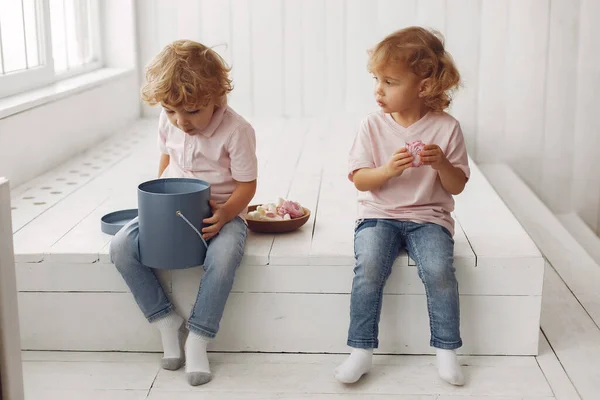 Roztomilé děti jedí sušenky doma — Stock fotografie