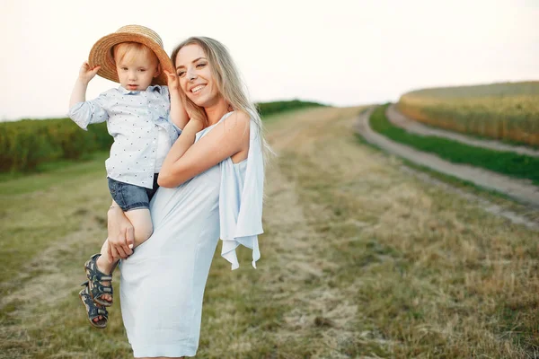 Mor med son leker på ett sommarfält — Stockfoto