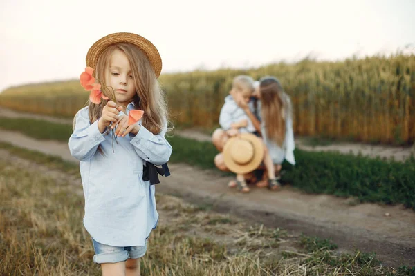 Moeder met kinderen spelen in een zomerveld — Stockfoto