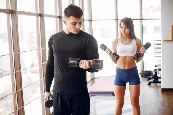 Un beau couple sportif est engagé dans une salle de gym — Photo
