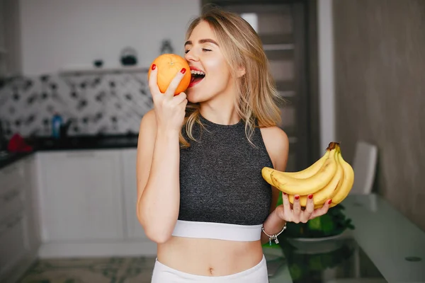 Спортивная девушка на кухне с фруктами — стоковое фото
