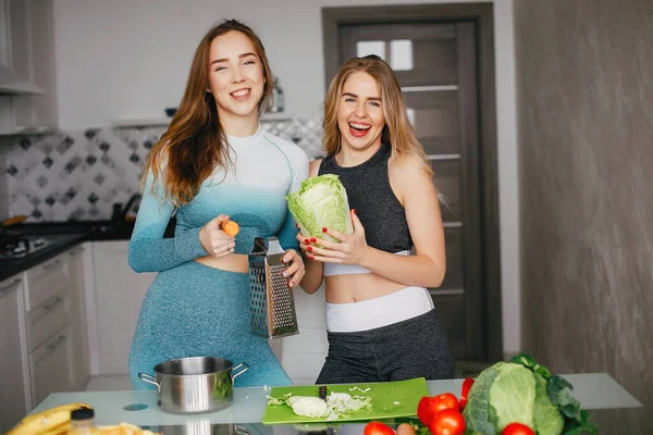 Deux sportives dans une cuisine avec des légumes — Photo