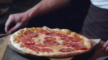 Restoranda servis edilen salamlı ve peynirli kesilmiş pizza.
