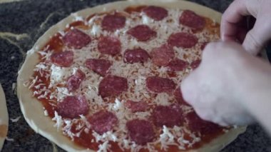 Lokantada pizzaya salam koyan şeflerin yakın çekimi.