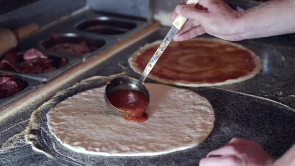 Küchenchef gießt Tomatensauce auf Teig — Stockvideo