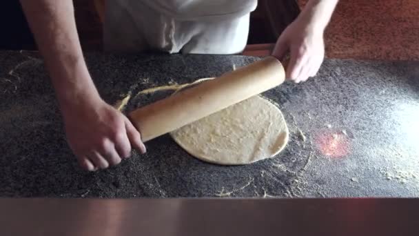 Шеф-повар держит булавку и месит тесто в ресторане — стоковое видео