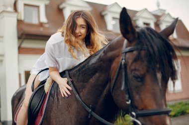 Güzel bir kadın atıyla ayakta duruyor