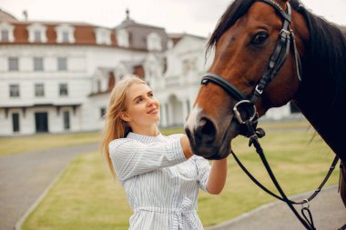 Güzel bir kadın atıyla ayakta duruyor