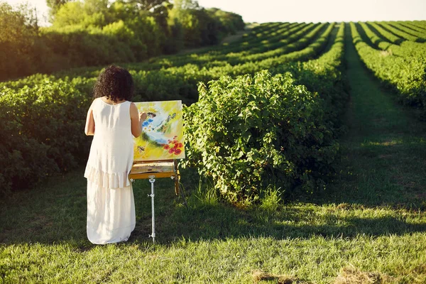Schöne erwachsene Frau zeichnet in einem Sommerfeld — Stockfoto