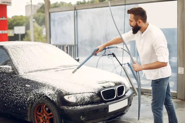Uomo che lava la sua auto in una stazione di lavaggio — Foto Stock