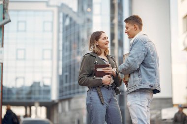 Üniversite kampüsündeki öğrenciler ellerinde kitaplarla.