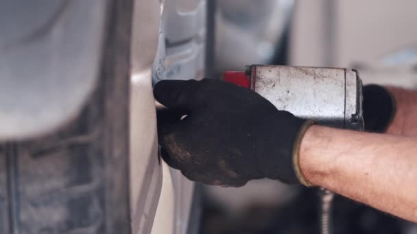 Werknemer in zwarte handschoenen maakt gebruik van gereedschap voor de vaststelling van auto — Stockvideo