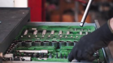 Garajdaki yeşil inşaatı tamir eden eldiven işçisi.