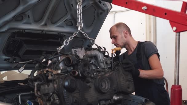 Ο άνθρωπος βάζει κινητήρα στο αυτοκίνητο μετά την επισκευή στο γκαράζ — Αρχείο Βίντεο