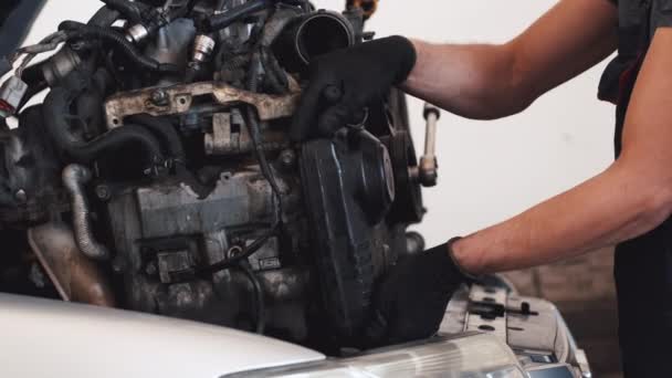 Primer plano mecánico en guantes reparación de motor de coche en garaje — Vídeo de stock