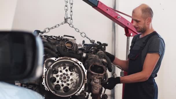 Worker in gloves removing engine of car in service center — Stock Video