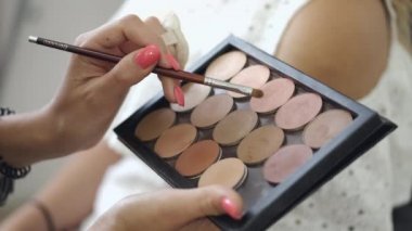 Göz gölgeli paleti tutan ellerin kırpılmış görüntüsü