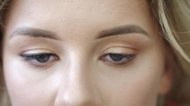 Makyaj sanatçısı salonda göz kalemiyle müşterilerin gözlerini çiziyor.