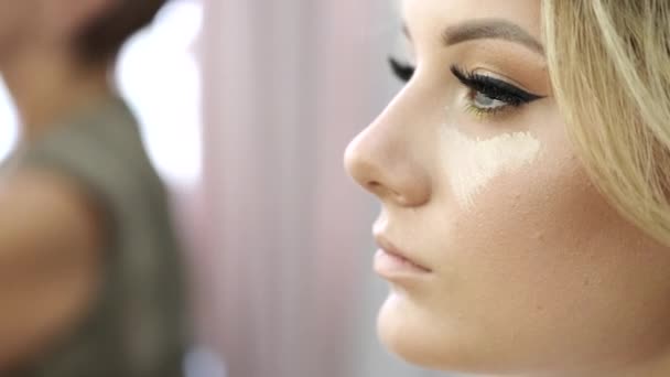 Beskuren vy över unga kvinnor ansikte med makeup i salongen — Stockvideo