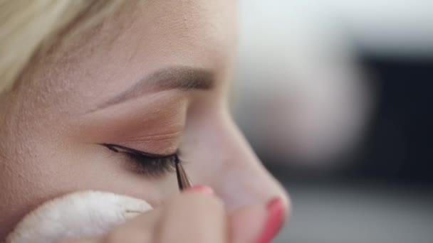 Maquillaje artista dibujar los ojos de los clientes con delineador de ojos en salón — Vídeo de stock