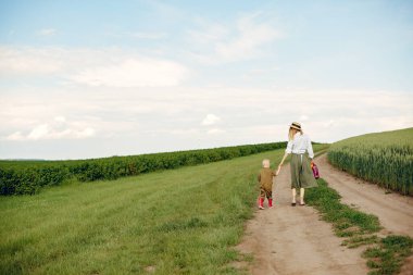 Güzel anne ve küçük oğlu yaz tarlasında