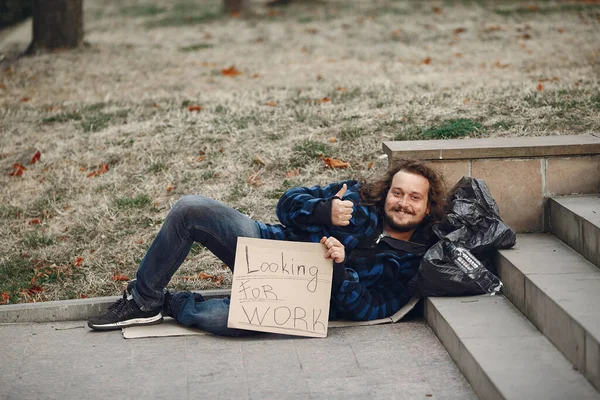 Homeless hombre en un durty ropa otoño ciudad — Foto de Stock