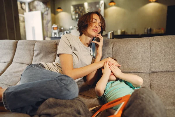 Matka s malým synem sedí doma na garantované — Stock fotografie