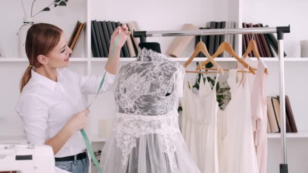 Γυναίκα ράφτης μετρά ένα μοντέλο από ένα υπέροχο φόρεμα — Αρχείο Βίντεο