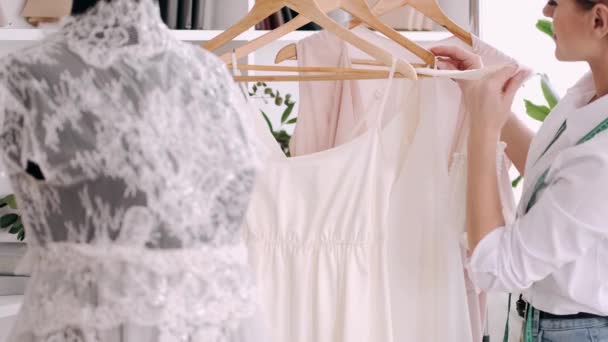 Vrouw kleermaker is het draperen van een tape aan een jurk waar ze aan werkt — Stockvideo