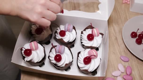 La mujer panadero está decorando cupcakes caseros con cerezas — Vídeo de stock