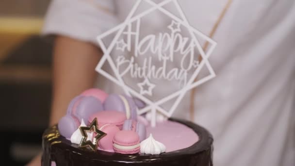 Mujer panadero está estableciendo feliz cumpleaños decoración en un pastel — Vídeos de Stock