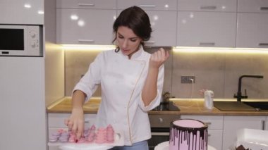 Güzel kadın pastacı mutfakta lezzetli makaronlar pişiriyor.