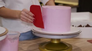 Kadın fırıncı modern bir mutfakta doğum günü pastası yapıyor.