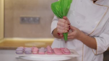 Gülümseyen bir fırıncı kadın makaron yapıyor.