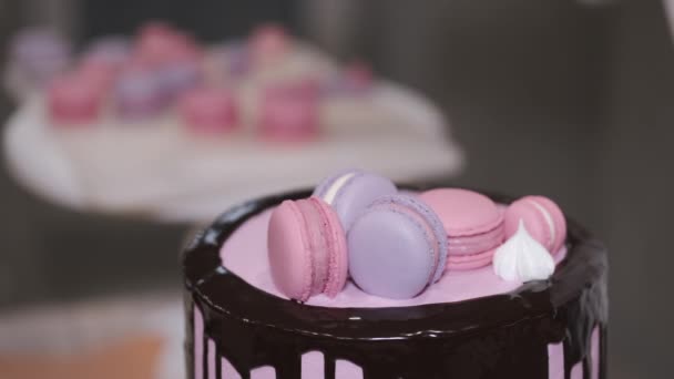 Mujer panadero está decorando un pastel de cumpleaños con macarrones en la parte superior — Vídeos de Stock