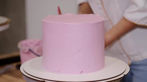 Женщина-пекарь готовит праздничный торт на современной кухне — стоковое видео
