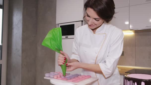 Eine lächelnde Bäckerin macht Macarons — Stockvideo