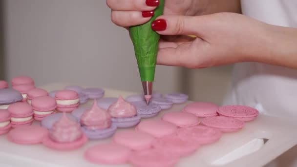 Uma mulher sorrindo padeiro está fazendo macarons — Vídeo de Stock