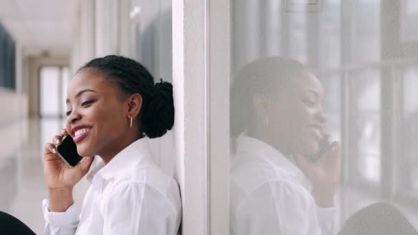 Africano-americano mulher está falando ao telefone e sorrindo no aeroporto — Vídeo de Stock