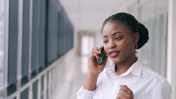 Αφροαμερικανή μιλάει στο τηλέφωνο και χαμογελάει στο αεροδρόμιο. — Αρχείο Βίντεο
