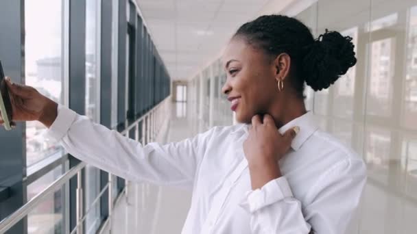 La joven afroamericana se está tomando selfies en el salón moderno — Vídeos de Stock